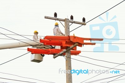 An Electrical Power Utility Worker In A Bucket Fixes The Power Line Stock Photo