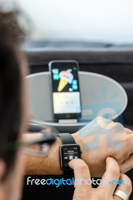 Apple Music - A Man Is Controlling The Music In His Living Room Using Watch With Iphone And Loudspeaker Stock Photo