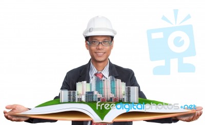 Architect Holding Green Field With Modern Building Stock Photo