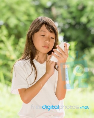 Asia Girl Use Smart Phone In Garden Stock Photo