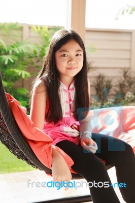 Asian Girl Relaxing On Cradle Stock Photo
