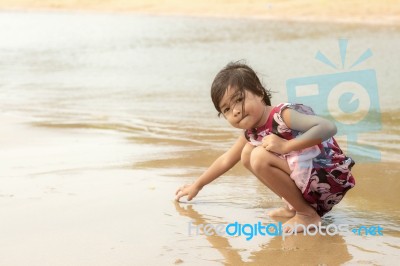 Asian Girl Sitting On Beach Stock Photo