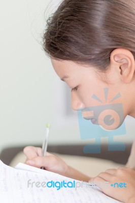 Asian Girl Writing On Lesson Book Stock Photo