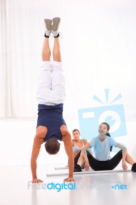 Asian Woman Looking Man Doing Handstand Exercise Stock Photo