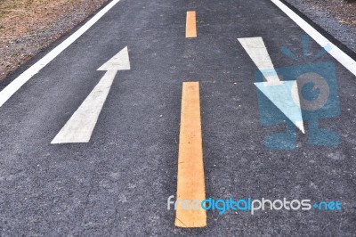 Asphalt Road And White Arrow Sign Marking On Road Surface Stock Photo