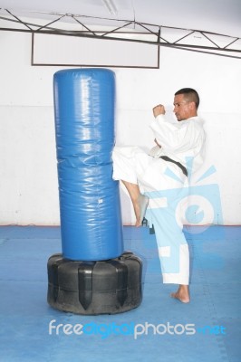 Athletic Black Belt Karate Giving A Forceful Knee Kick During A Stock Photo