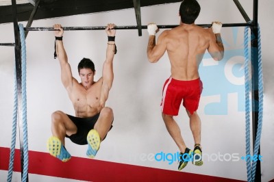 Athletic Group Executing Exercise Tightening On Horizontal Bar Stock Photo