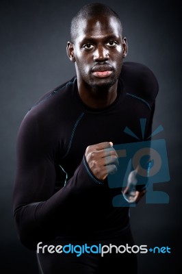 Athletic Man Running In Black Background Stock Photo