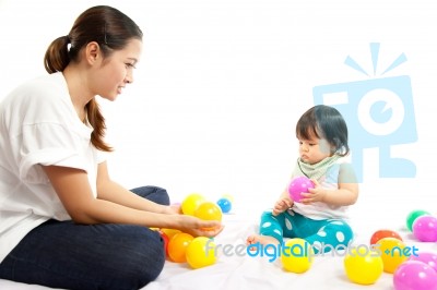 Baby Girl Is Playing Ball With Her Mother On White Background Stock Photo