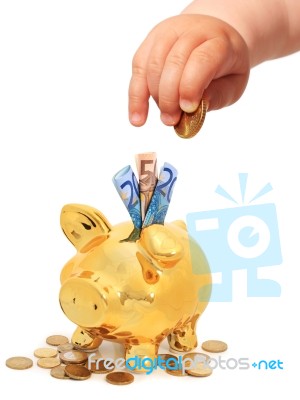 Baby's Hand With Coin And Piggybank Stock Photo
