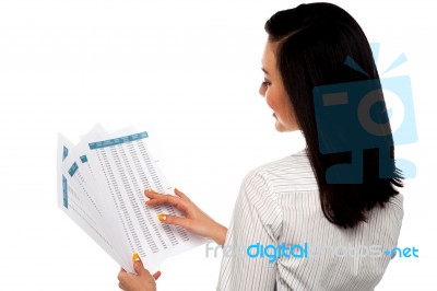 Back Pose Of Businesswoman Reading Reports Stock Photo