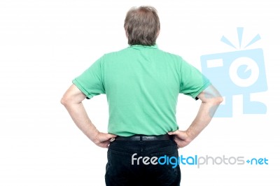 Back Pose Of Elderly Guy With Hands On His Waist Stock Photo