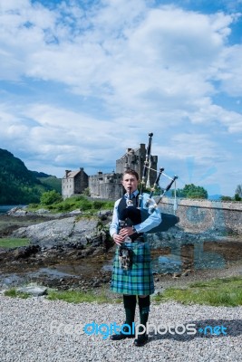 Bagpipe Player At Famous Eilean Donan Castle In Scotland Stock Photo