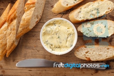 Baguette With Herb Butter And Rosemary Thyme On Rustic Wooden Background Stock Photo