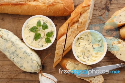 Baguette With Herb Butter And Rosemary Thyme On Rustic Wooden Background Stock Photo