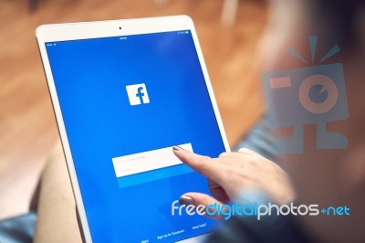 Bangkok, Thailand - January 16, 2018 : Hand Is Pressing The Facebook Screen On Apple Ipad Pro,social Media Are Using For Information Sharing And Networking Stock Photo