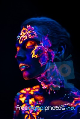 Beautiful Flowers In Uv Light On A Young Girl Face And Body Stock Photo