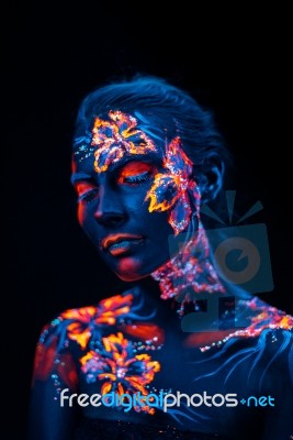 Beautiful Flowers In Uv Light On A Young Girl Face And Body Stock Photo