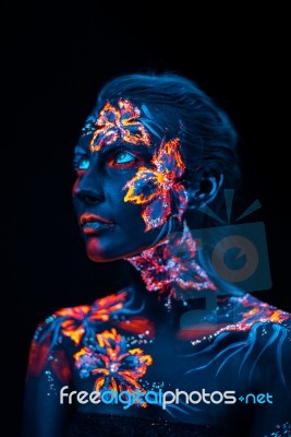 Beautiful Flowers In Uv Light On A Young Girl Face And Body Stock Photo