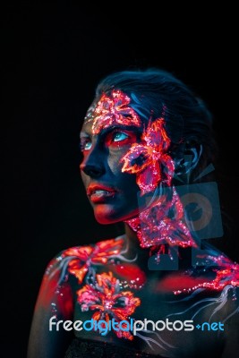 Beautiful Flowers In Uv Light On A Young Girl Face And Body Stock Photo