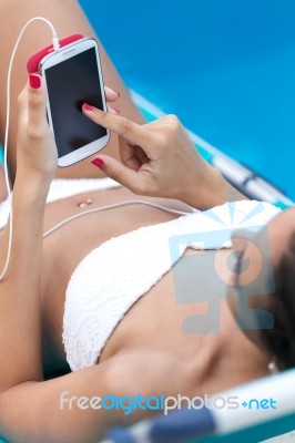 Beautiful Girl Listening To Music In The Swimming Pool Stock Photo