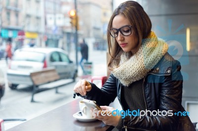 Beautiful Girl Using Her Mobile Phone In Cafe Stock Photo
