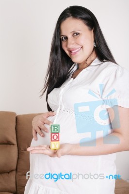 Beautiful Hispanic Pregnant Woman Having The Word Boy With Woode… Stock Photo