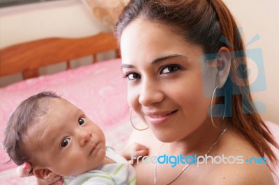 Beautiful Hispanic Young Mother Is Holding Her Newborn Baby Stock Photo