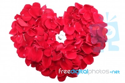 Beautiful Ring In The Middle Of A Heart Of Red Roses Petals Stock Photo