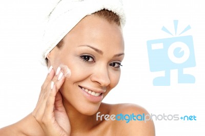 Beautiful Woman Applying Lotion On Her Face Stock Photo