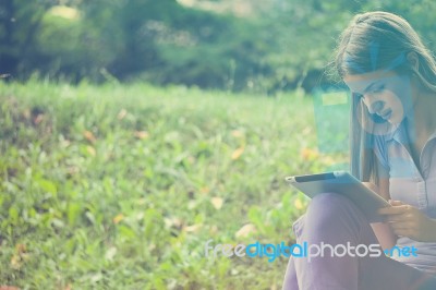 Beautiful Woman With Tablet Computer In Park Stock Photo