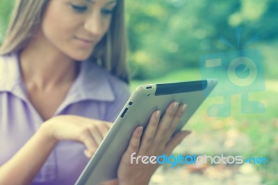 Beautiful Woman With Tablet Computer In Park Stock Photo