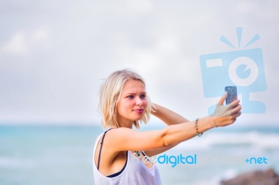 Beautiful Young Blonde Woman Posing Outdoor At The Rocky Sea Sho… Stock Photo Beautiful Young Blonde Woman Posing Outdoor At The Rocky Sea Sho… Stock Photo