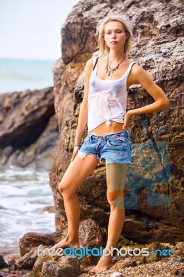 Beautiful Young Blonde Woman Posing Outdoor At The Rocky Sea Sho… Stock Photo