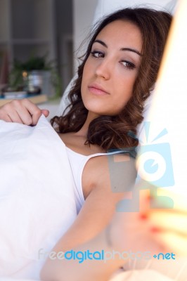 Beautiful Young Woman Turning Off The Lamp Stock Photo
