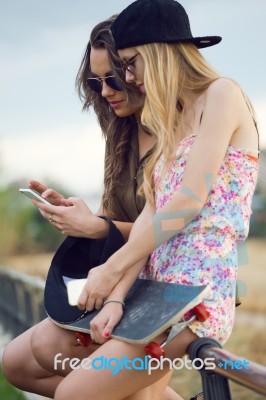 Beautiful Young Women Using Mobile Phone In The Street Stock Photo