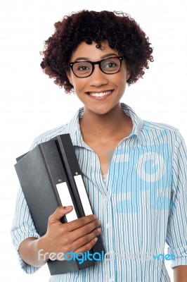 Bespectacled Woman In Casuals Holding Files Stock Photo
