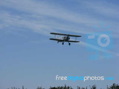 Biplane In Flight With Clouds Stock Photo