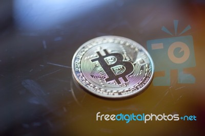 Bitcoin Curency Coin On Glass Table Stock Photo