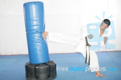Black Belt Karate Man Practicing In A Sandbag Stock Photo
