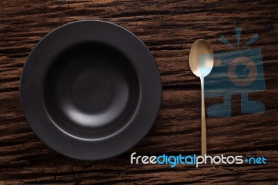 Black Empty Bowl Spoon On Wooden Table Background Stock Photo