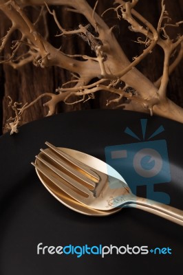 Black Empty Plate Fork Spoon On Wooden Table Background Stock Photo