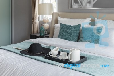 Black Hat On Green Blanket On Bed In Luxury Bedroom Stock Photo