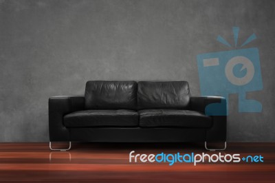 Black Sofa With Wooden Floor Concrete Wall In Empty Living Room Stock Photo