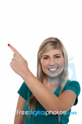 Blonde Girl Pointing Away On White Background Stock Photo