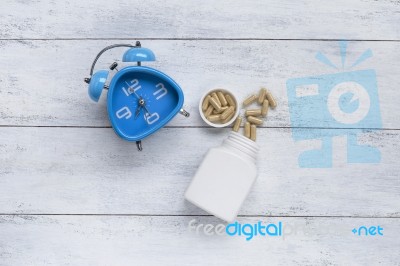 Blue Clock With Herb Capsule Stock Photo