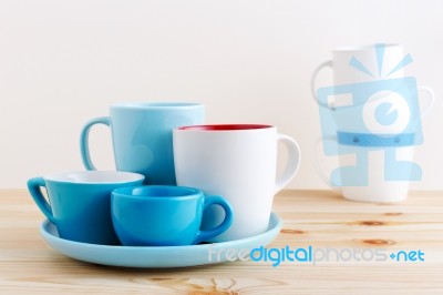 Blue Cups And White Mug On Wood Table Stock Photo