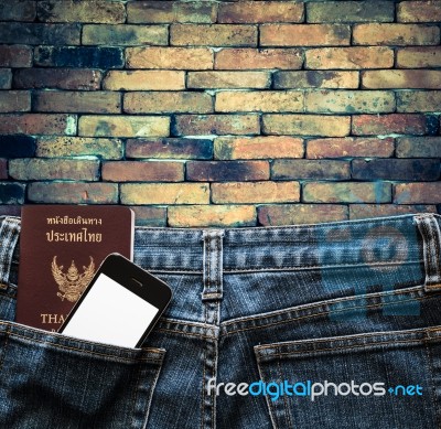 Blue Jeans With Cell Phone And Passport In A Pocket Background Stock Photo