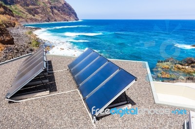 Blue Solar Panels On Roof At Sea Stock Photo