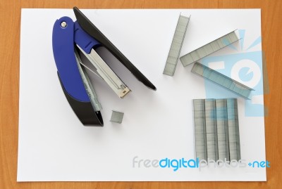 Blue Stapler And Staples With Paper On The Table Stock Photo